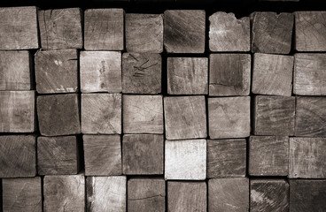 Stack of squared lumbers. Pile of wood in timber logs storage, A material for architectural and structural construction or industrial work for background and texture.