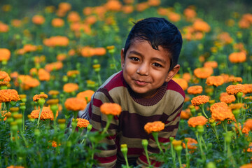 A joyful child smiling in a marigold garden, surrounded by golden blooms and green leaves symbolizing happiness, hope, peace, and a bright green future filled with nature’s warmth and innocence