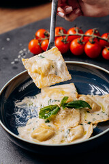 Fork lifting creamy basil ravioli, a perfect Italian gourmet dish for elegant food photography