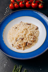 Creamy porcini mushroom risotto served on a blue plate with parmesan garnish