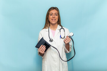 Smiling doctor woman holding sphygmomanometer and stethoscope on blue background