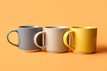 Ceramic cups on orange background