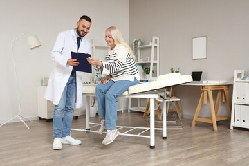 Male doctor working with mature woman in clinic