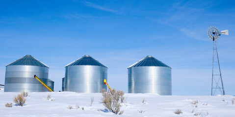 Windmill and Grain Silos in Winter Snow on Farm for Agricultural Farming © Lane Erickson