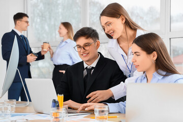 Business people with laptop negotiating at table in conference hall