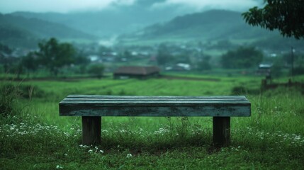 Fototapeta premium Serene Wooden Bench Overlooking Misty Green Valley Landscape