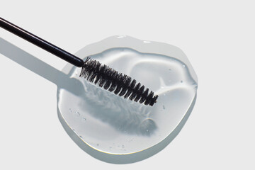 Cosmetic eyelashes and eyebrows care or styling oil gel texture swatch with black applicator brush...