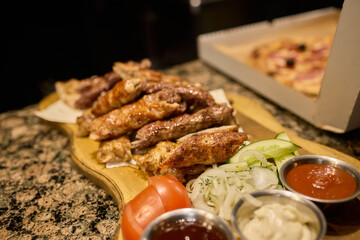 Enjoying Delicious Chicken Wings Accompanied by Fresh Sides and Tasty Sauces for All