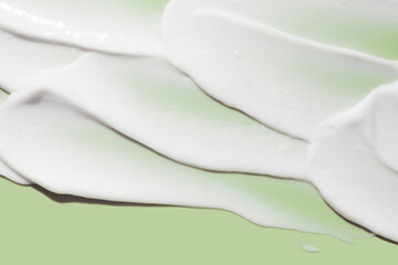 Face or eye cosmetic product white cream hair balm green sage background