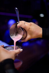 Expertly Crafting a Beautiful Pink Cocktail with Attention to Precision and Detail