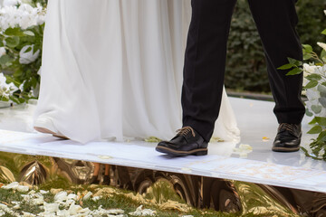 newlyweds step onto a towel at the wedding ceremony