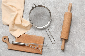 Set of kitchen utensils with metal sieve on grunge background