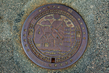 Bergen manhole cover depicting sailing ships and trading houses