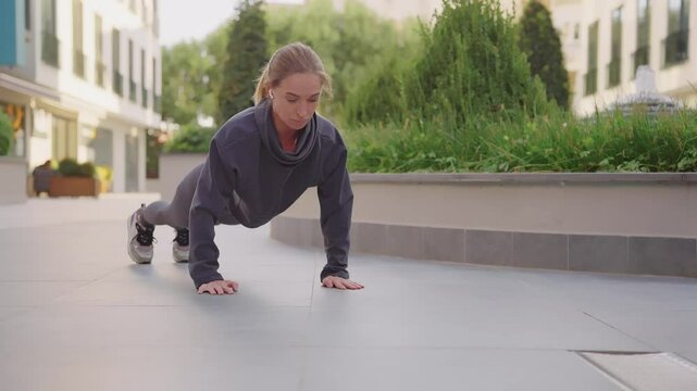 A woman performs strength training in an urban environment. Fitness. Strength and efficiency are her top priorities.