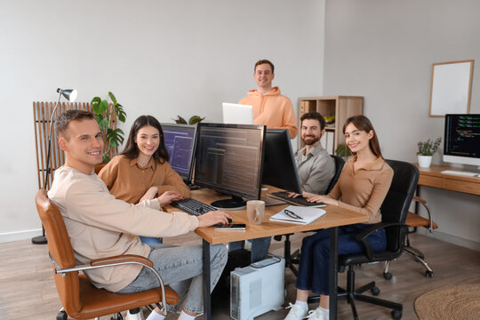 Team of programmers working at table in office