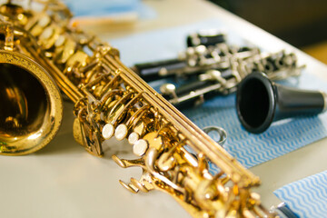 Golden saxophone and clarinet resting on table after cleaning