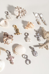 Various natural pearl pendants and seashells on white background. Vertical