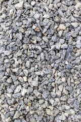 Close-up of rough gray gravel texture with various stone sizes