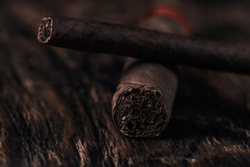 Cigar on dark wooden background. Selective focus.