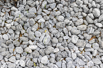 Gray pebbles background texture with natural stones in random arrangement