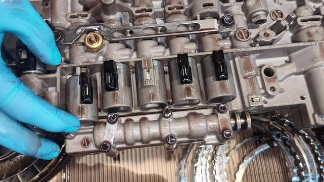 Hydraulic control plate of an automatic transmission, missing solenoid lock retainer of the torque converter. Professional repair at an auto service