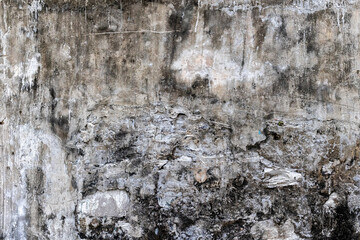 Weathered concrete wall with peeling paint and textured surface