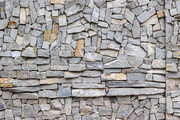 Interlocking gray stone wall with varied textures and patterns