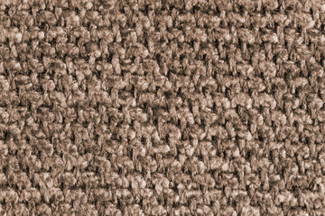 Texture of brown jacquard fabric, close up of rough weave macro. Material for home textile, upholstery and curtain decor, garment. Background, wallpaper, backdrop.
