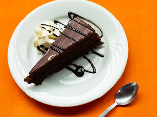 Delicious dessert chocolate cake on saucer with chocolate topping