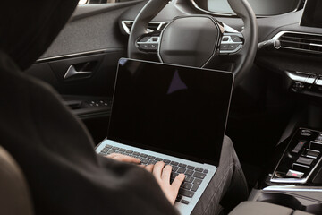 Thief hacking car system with laptop inside vehicle, closeup