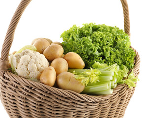 Different fresh vegetables in wicker basket isolated on white