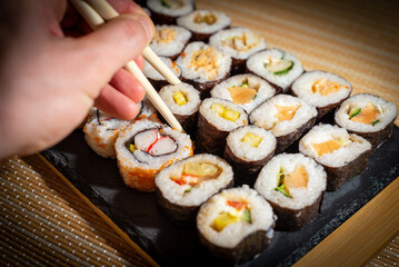 Eating delicious sushi rolls. Enjoying healthy Japanese food