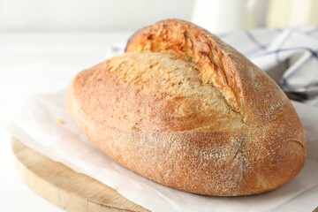 Loaf of delicious bread on white wooden table, closeup