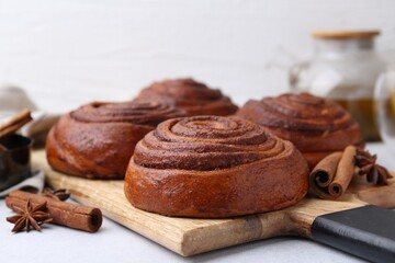 Delicious cinnamon roll buns on light table, closeup