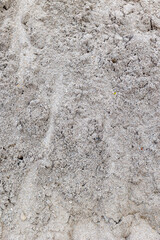 Close-up view of fine textured natural sand surface in sunlight