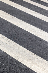 Close-up of a urban pedestrian crosswalk with textured asphalt patterns