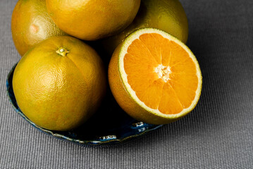 Ripe half of chocolate orange fruit on dark background without shadow.