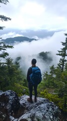 Hiker standing on mountain peak under cloudy sky
