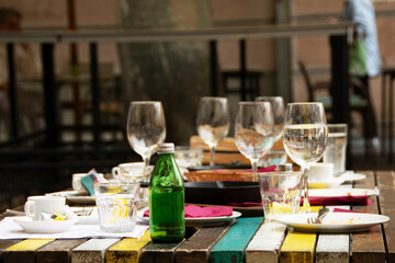 Messy Food after meal, waste, leftover food on plate after lunch with group of friends. Tourists table after dinner outdoors
