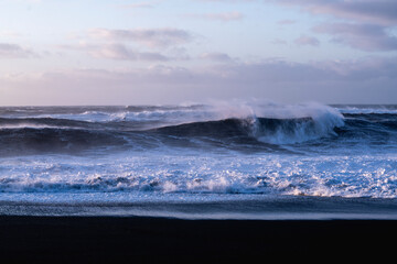 rough morning ocean wave at black beach in Iceland sunrise pretty colours close up