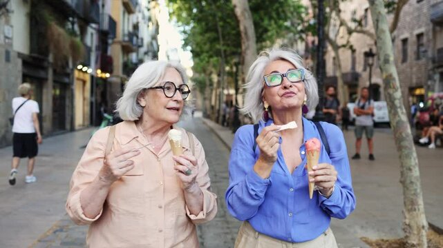 Senior women tourists enjoying ice cream in barcelona