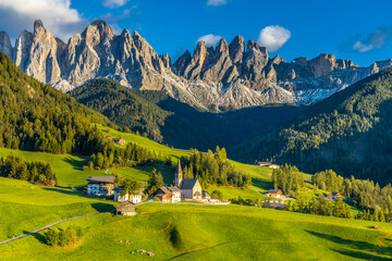 Panorama of Santa Maddalena village and church in the Dolomites, Puez Odle national park in Italy. Italian Dolomiti Alps scenic landscape in summer with beautiful sunlight at sunset