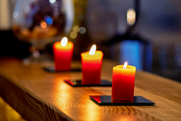 Three red candles sitting on top of a wooden table