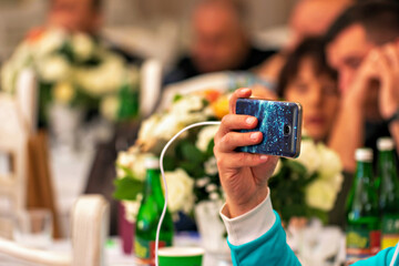 A man taking a picture of a group of people at a wedding reception