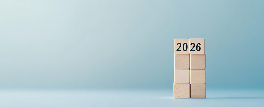 Modern wooden blocks displaying the year 2026 on a soft blue background for inspirational themes