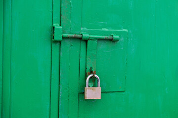 A green door with a padlock attached to it