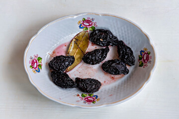 A white plate topped with dried prunes on top of a table
