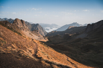 A golden summer trail winding through the picturesque French Pyrenees at dawn.