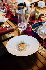 Gourmet poached pear dessert served on an elegant dining table with chic decor and fine wine