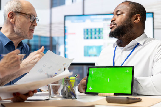 Financial broker meeting with elderly couple to discuss life insurance, using green screen on tablet and choosing a suitable retirement option. Mature clients investing life savings. - Powered by Adobe